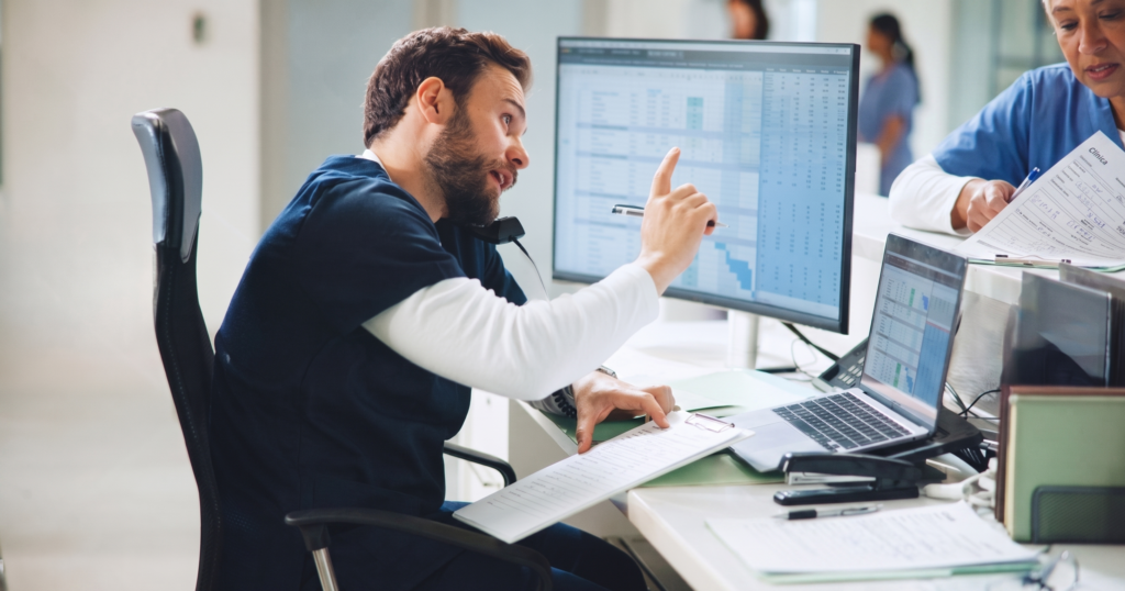 Profesional sanitario gestionando citas y datos de pacientes en el ordenador de una clínica